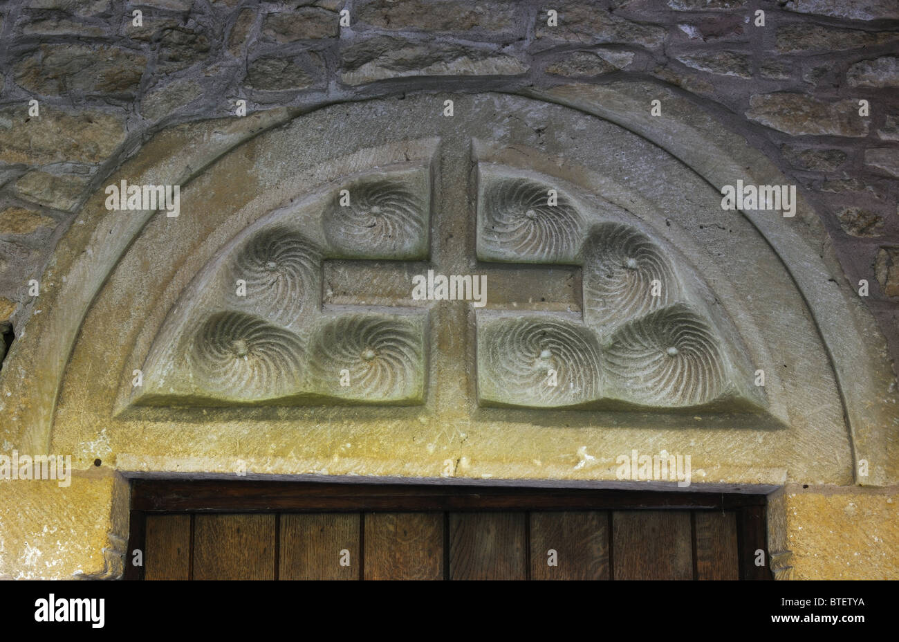 Tympanum over doorway of St. Peter`s Church, Little Comberton, Worcestershire, England, UK Stock Photo